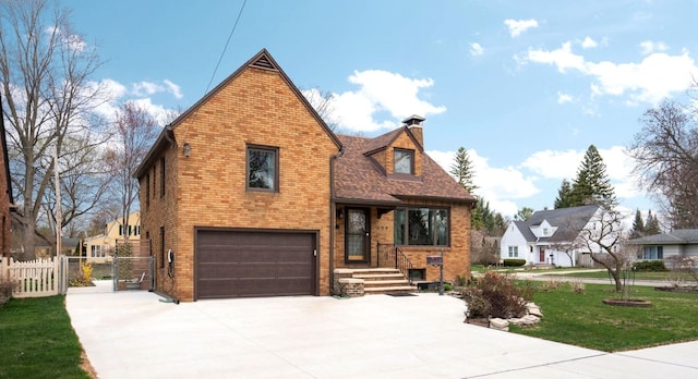 609 Fillmore Pl, Bay City, MI 48708 - view of front facade featuring brick siding, fence, a garage, concrete driveway, and a gate