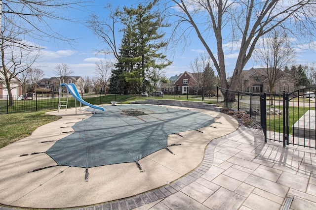 1348 Cartwright Ln, South Lyon, MI 48178 - view of swimming pool with a fenced in pool, a water slide, fence, and a lawn