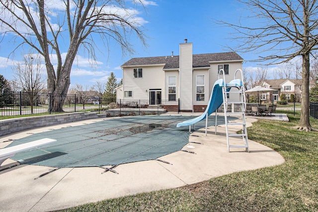 1348 Cartwright Ln, South Lyon, MI 48178 - view of pool with a fenced in pool, a water slide, fence, a patio area, and a diving board