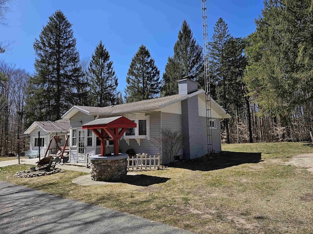 view of front of home featuring a chimney and a front lawn