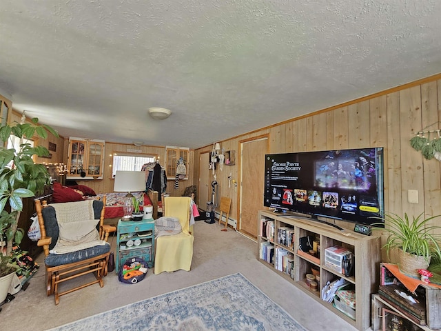 carpeted living room featuring a baseboard heating unit, a textured ceiling, and wooden walls