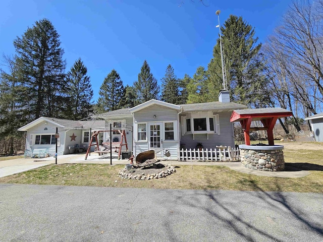 single story home featuring a chimney and fence