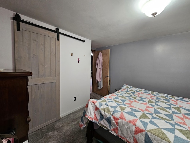 bedroom with a barn door, carpet flooring, and baseboards