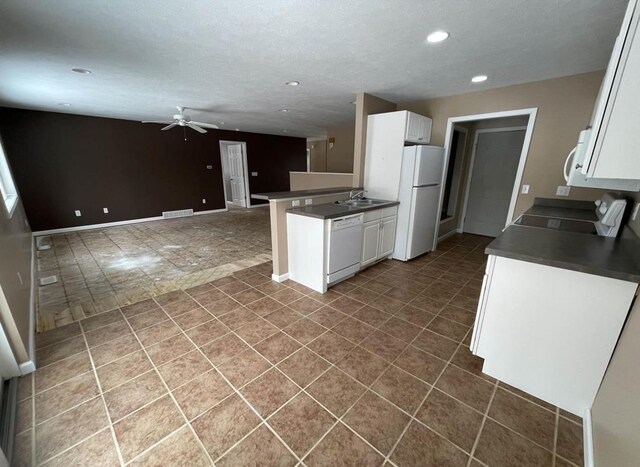 835 Eden St, Kingsley, MI 49649 - kitchen with white cabinets, dark countertops, visible vents, white appliances, and ceiling fan