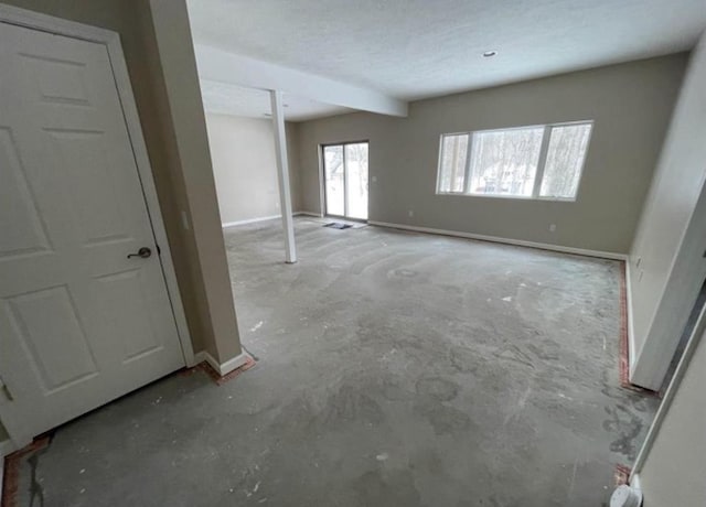 835 Eden St, Kingsley, MI 49649 - unfurnished living room featuring unfinished concrete floors and baseboards