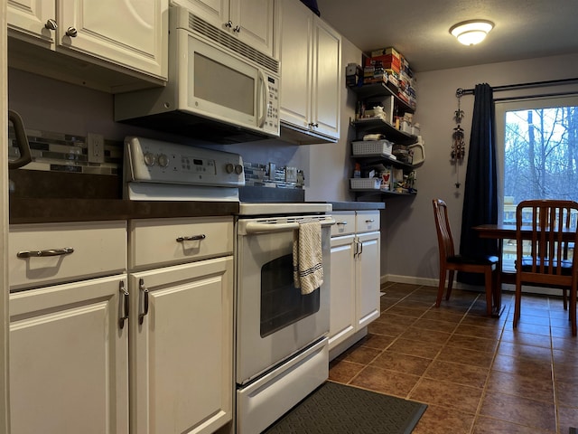 835 Eden St, Kingsley, MI 49649 - kitchen with white cabinets, baseboards, dark countertops, and white appliances