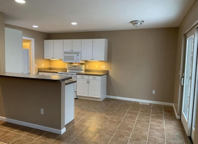 835 Eden St, Kingsley, MI 49649 - kitchen featuring white cabinets, electric range oven, white microwave, and recessed lighting