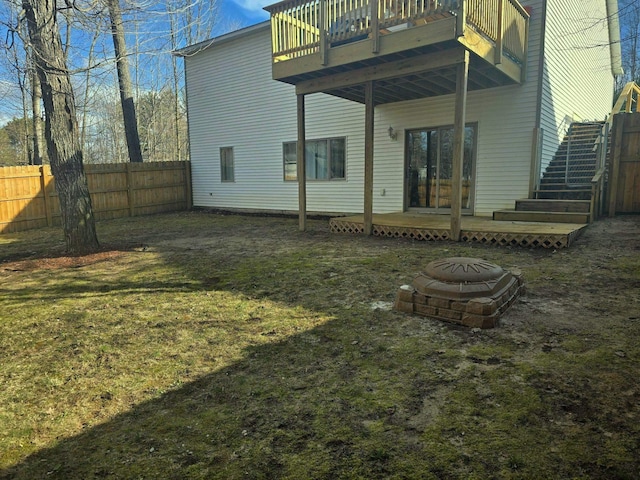 835 Eden St, Kingsley, MI 49649 - back of property with stairway, a lawn, a deck, an outdoor fire pit, and fence