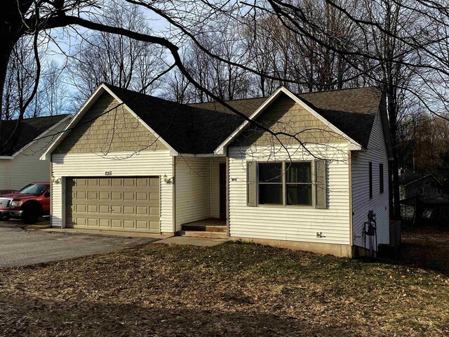 835 Eden St, Kingsley, MI 49649 - ranch-style home with a shingled roof, driveway, and a garage