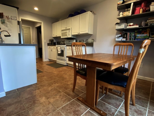 835 Eden St, Kingsley, MI 49649 - dining space featuring baseboards, dark tile patterned floors, and recessed lighting