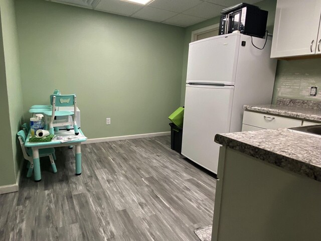 835 Eden St, Kingsley, MI 49649 - kitchen with white cabinets, freestanding refrigerator, wood finished floors, and baseboards