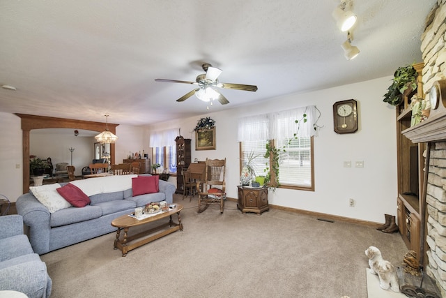 9155 Ivanhoe Dr, Onekama, MI 49675 - carpeted living area featuring a ceiling fan, baseboards, a fireplace, and a textured ceiling