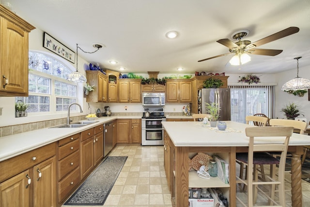 9155 Ivanhoe Dr, Onekama, MI 49675 - kitchen with a healthy amount of sunlight, stainless steel appliances, light countertops, and a sink
