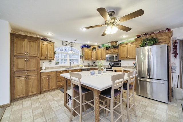 9155 Ivanhoe Dr, Onekama, MI 49675 - kitchen with light countertops, a ceiling fan, stainless steel appliances, and a sink