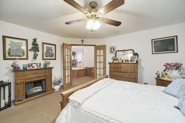 9155 Ivanhoe Dr, Onekama, MI 49675 - bedroom with a fireplace with raised hearth, ensuite bath, carpet flooring, and a ceiling fan