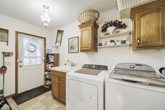 9155 Ivanhoe Dr, Onekama, MI 49675 - laundry room featuring cabinet space, washing machine and clothes dryer, light floors, and a sink