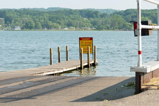 9155 Ivanhoe Dr, Onekama, MI 49675 - view of dock with a wooded view and a water view