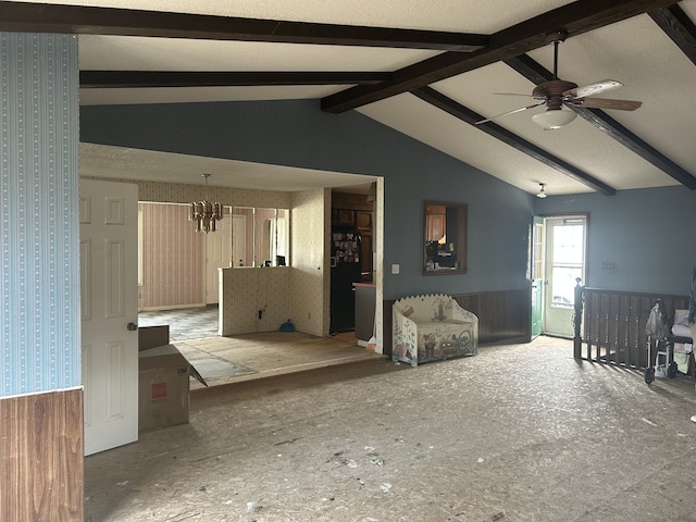 living room featuring wallpapered walls, a wainscoted wall, lofted ceiling with beams, and ceiling fan with notable chandelier