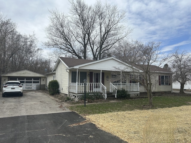 view of front of home with an outdoor structure, a garage, a front yard, and covered porch