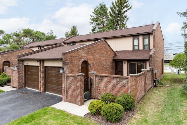 view of front of property featuring brick siding, driveway, roof with shingles, and a garage