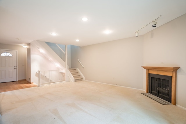 unfurnished living room featuring a fireplace with flush hearth, recessed lighting, stairway, carpet floors, and baseboards