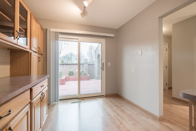 entryway with baseboards, visible vents, and light wood-type flooring