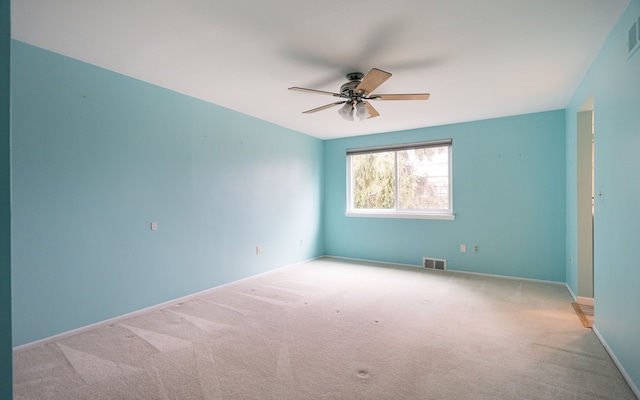 spare room with ceiling fan, baseboards, carpet flooring, and visible vents
