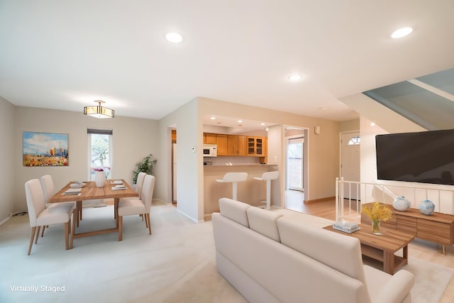 living room featuring recessed lighting, baseboards, and plenty of natural light