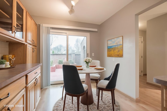 dining area featuring light wood-style floors and baseboards