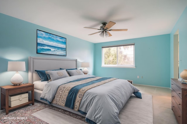 bedroom featuring light carpet, a ceiling fan, and baseboards