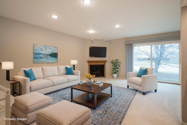 living room with baseboards, carpet floors, a fireplace with raised hearth, and recessed lighting