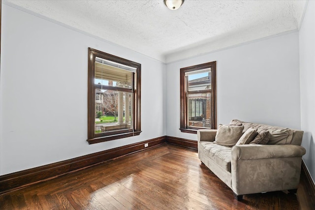 sitting room with a textured ceiling, dark wood-style floors, and baseboards