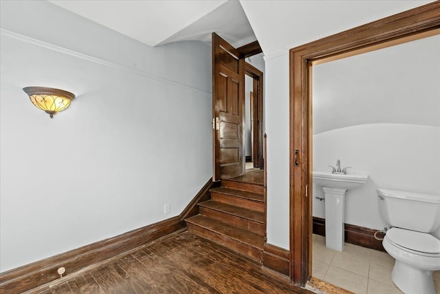 stairway with baseboards and tile patterned floors