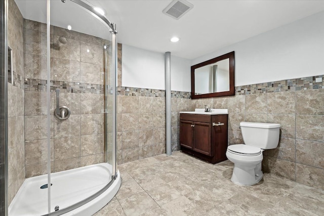 full bathroom featuring vanity, toilet, tile walls, a shower stall, and visible vents