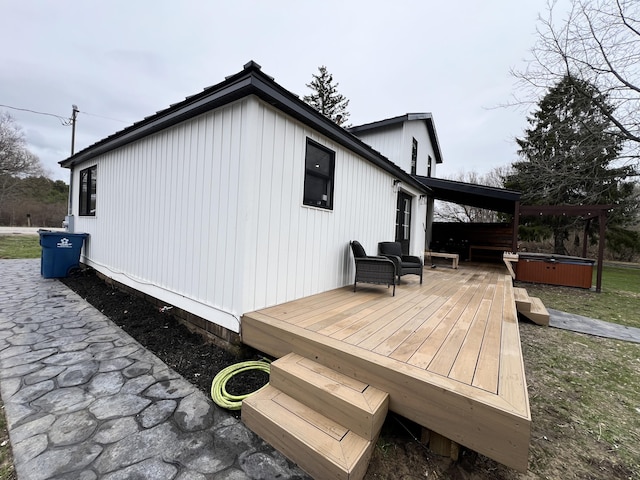view of property exterior featuring a wooden deck and a hot tub