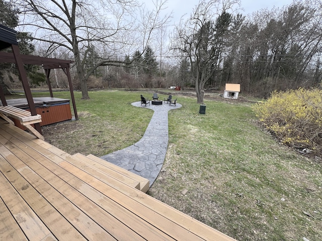 view of yard with a wooden deck, a hot tub, and an outdoor fire pit