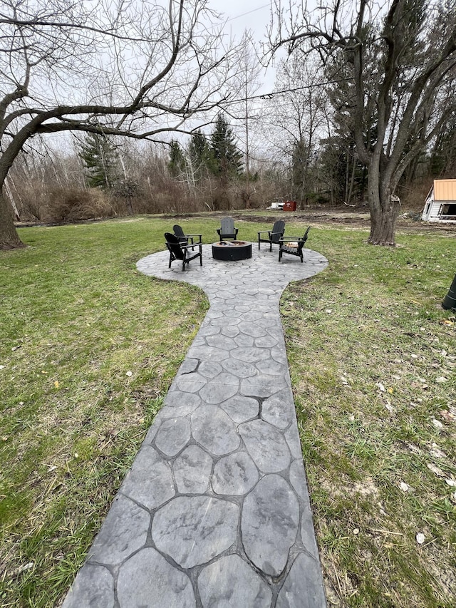 surrounding community with a yard and an outdoor fire pit