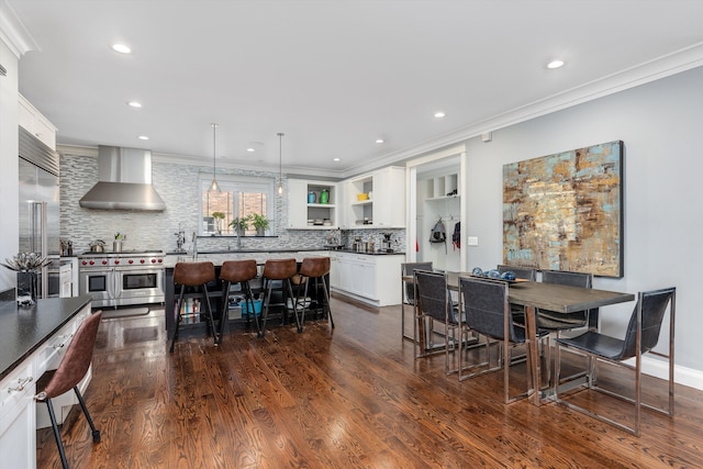 dining room featuring recessed lighting, ornamental molding, and dark wood finished floors