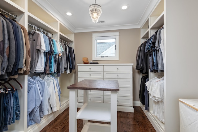 walk in closet with a notable chandelier, visible vents, and dark wood-type flooring