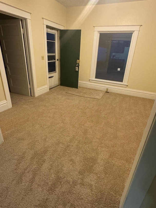 empty room with carpet and baseboards