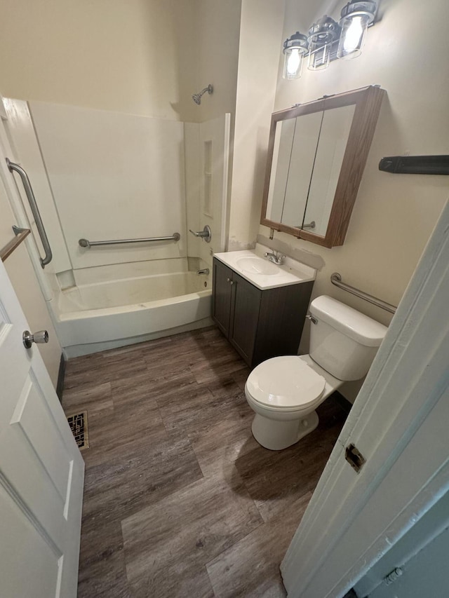 bathroom featuring wood finished floors, visible vents, toilet, vanity, and shower / tub combination