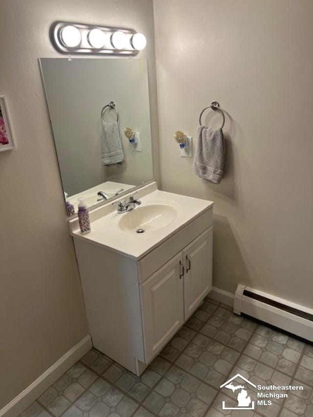 bathroom featuring a baseboard heating unit, baseboards, and vanity