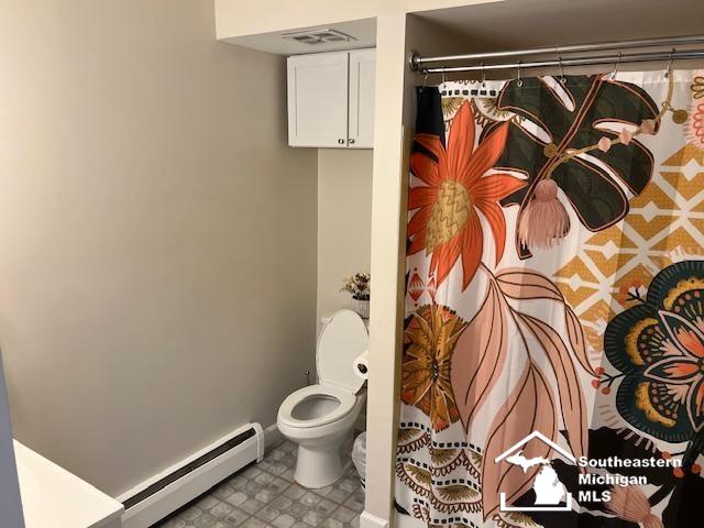 bathroom featuring visible vents, curtained shower, a baseboard radiator, and toilet