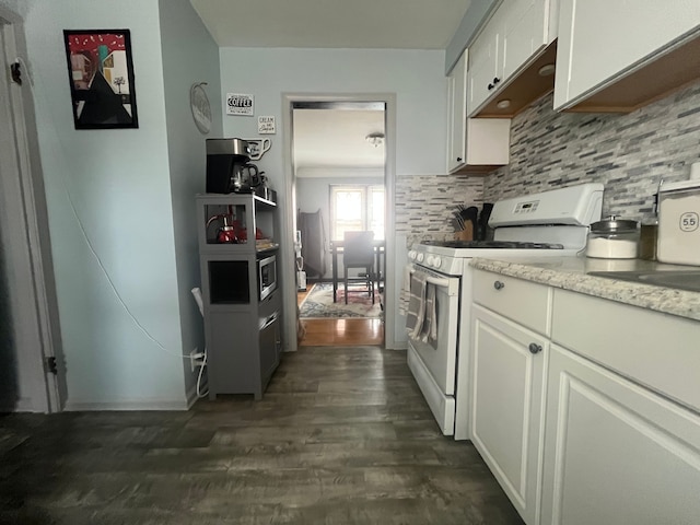 kitchen featuring white cabinets, backsplash, white range, dark wood-type flooring, and light stone countertops