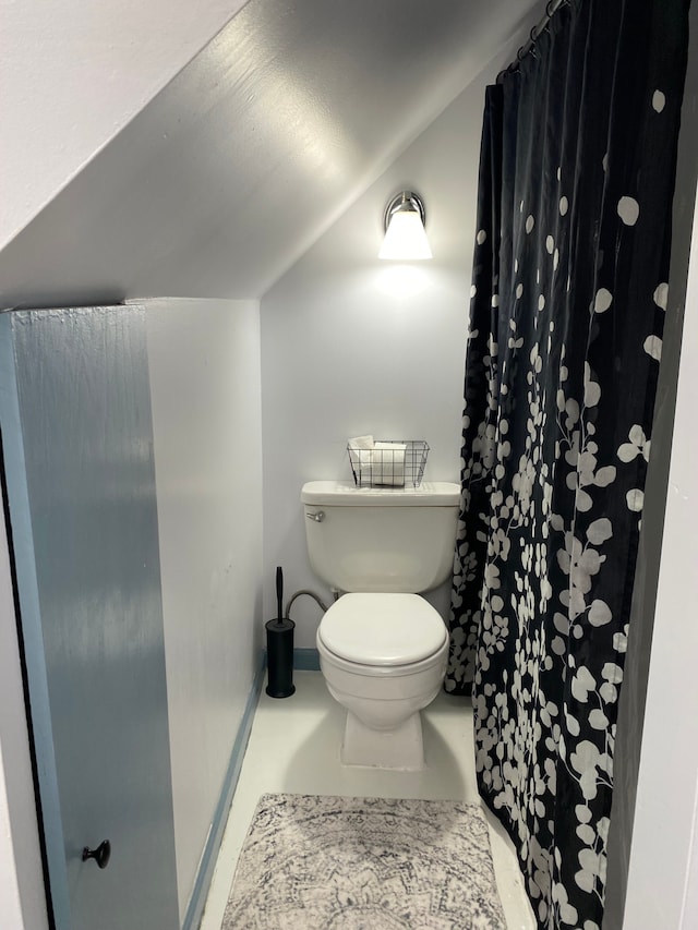 bathroom with toilet, lofted ceiling, curtained shower, and baseboards