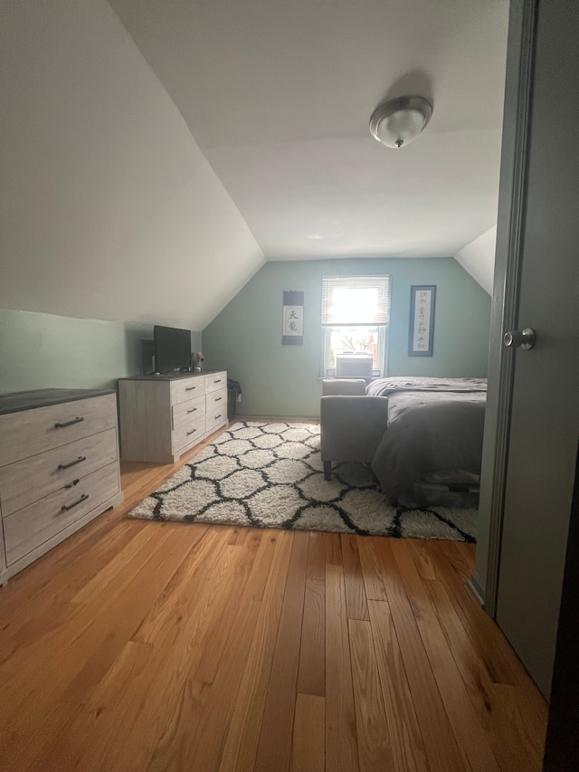 bedroom with vaulted ceiling and wood finished floors