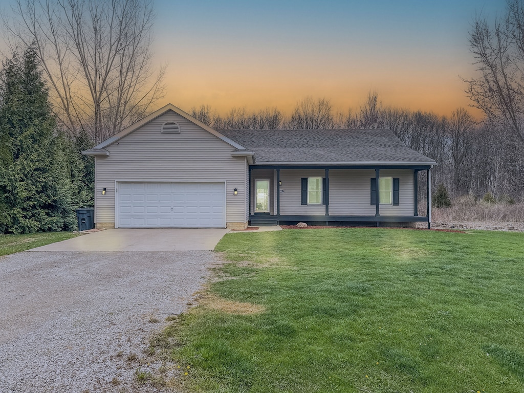 6310 Maple Ave, Swartz Creek, MI 48473 - view of front of house featuring driveway, covered porch, a yard, and a garage
