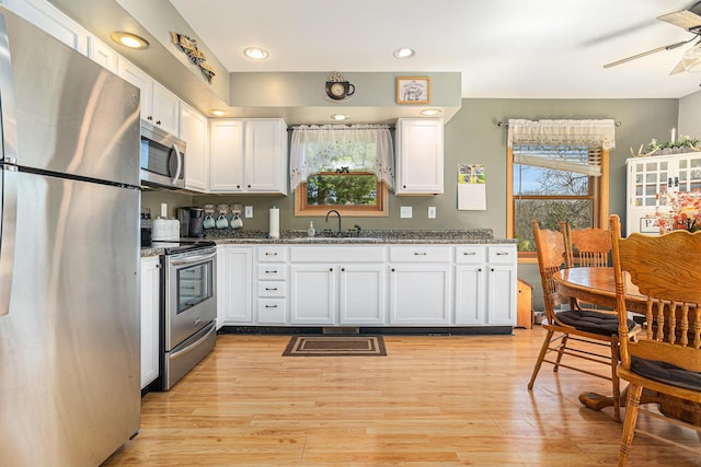 kitchen with white cabinets, a healthy amount of sunlight, appliances with stainless steel finishes, and a sink