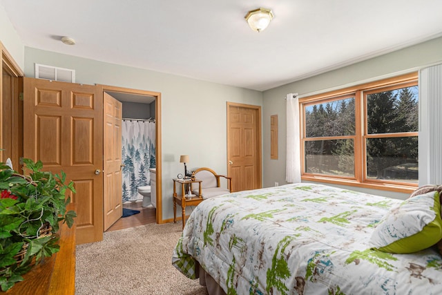 bedroom featuring connected bathroom, light carpet, and visible vents