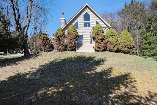 view of front facade with a chimney and a front yard
